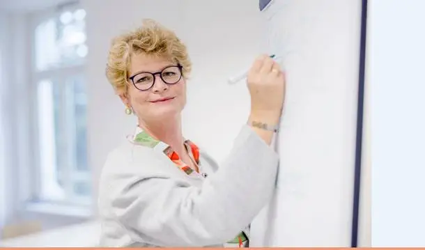 Inhaberin Susanne Erley vor einem Flipchart auf dem Sie Notizen zur Visualisierung des Projektmanagements erstellt.